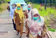 Warga Berjalan Kaki Saat Melintas di Jembatan Besi Desa Karya Mulya
